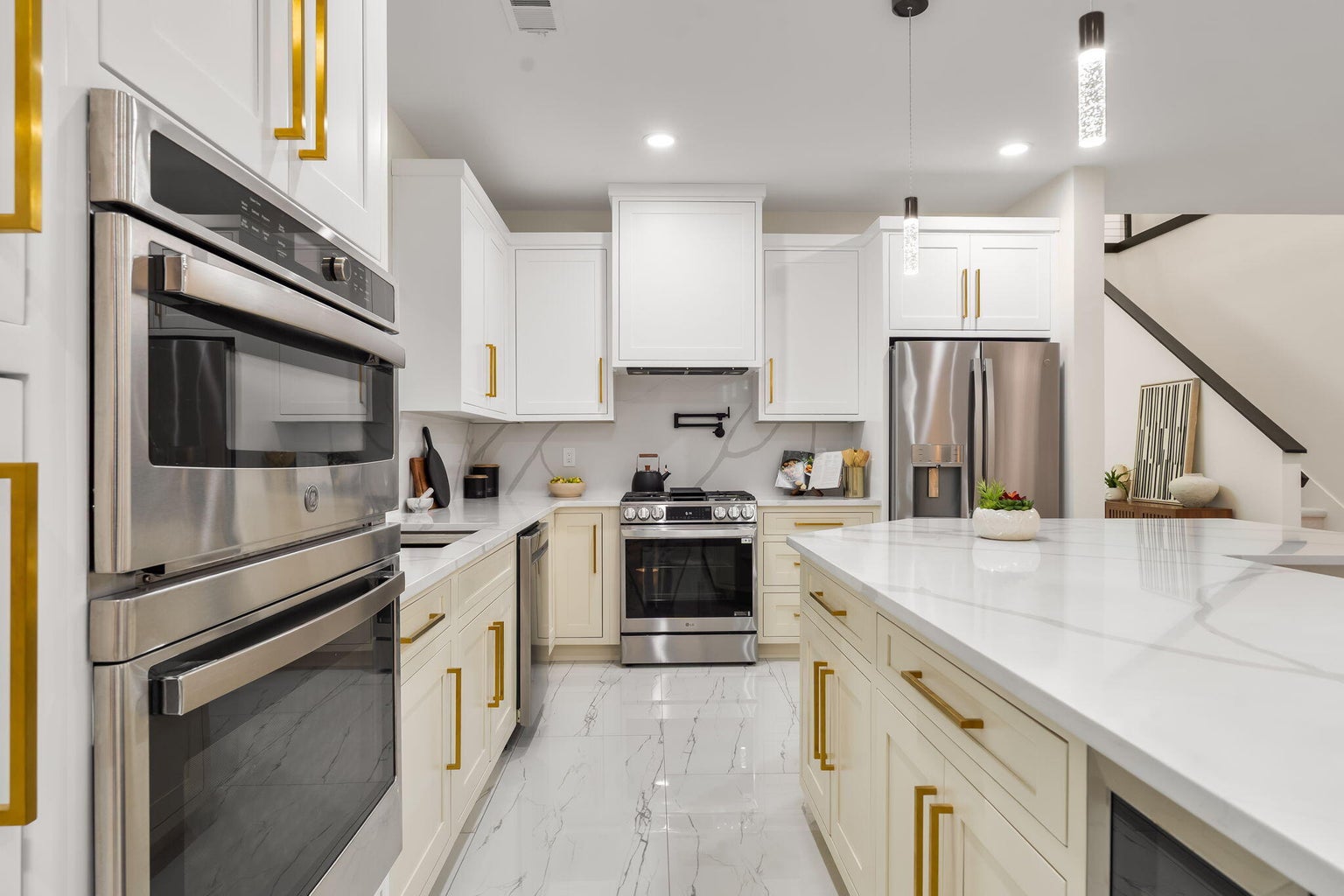 Kitchen at 1136 Turner Drive NE in Albuquerque, showing a large island, white cabinetry, gold-tone finishes, and a bright contemporary design.