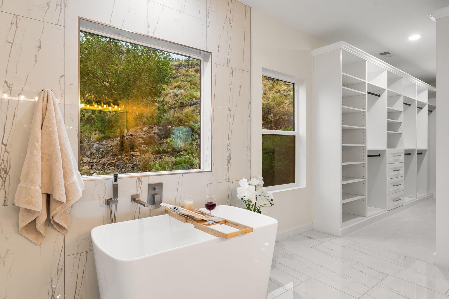 Primary bathroom at 1136 Turner Drive NE in Albuquerque, showing a soaking tub, modern finishes, and mountain views outside.