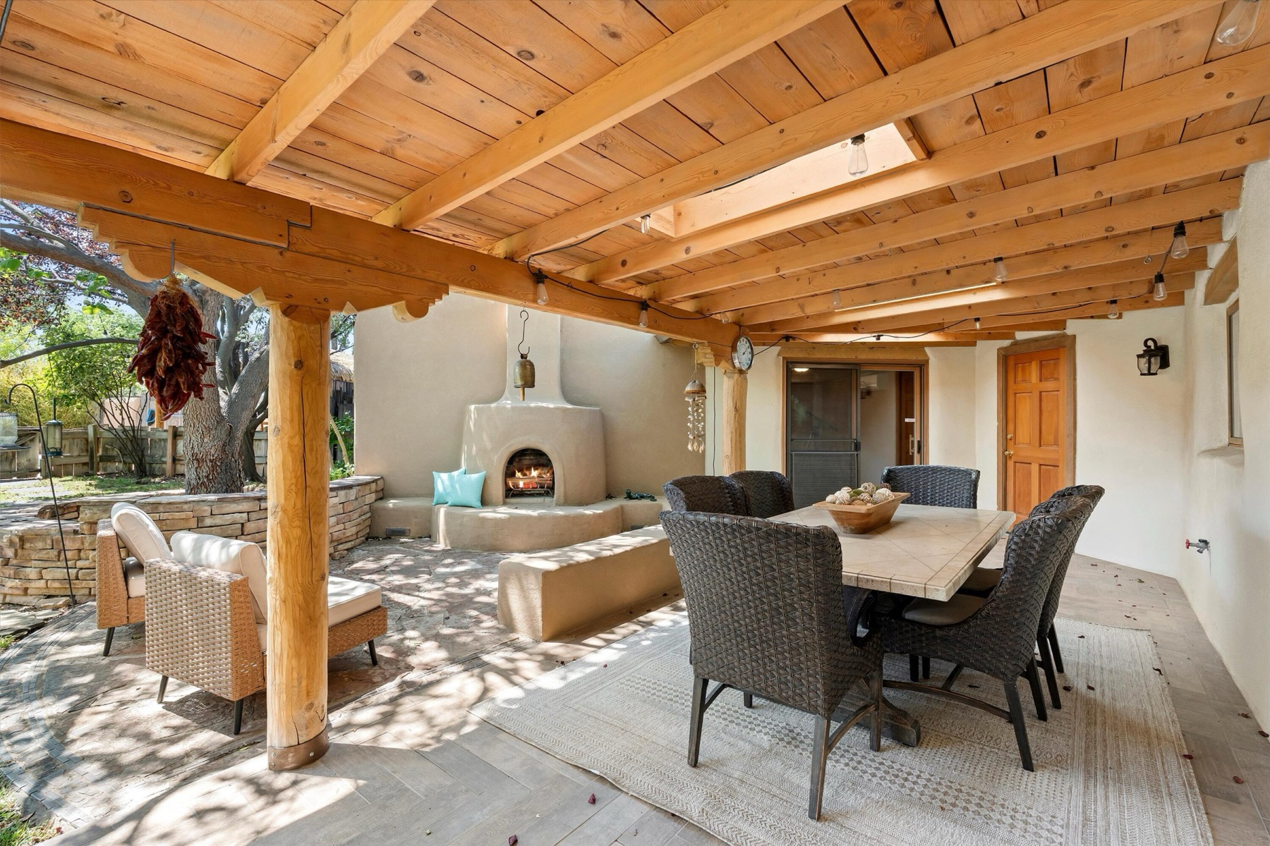 Covered portal with wood posts, outdoor seating, fireplace, and garden views at 4068 Dietz Farm Circle NW.
