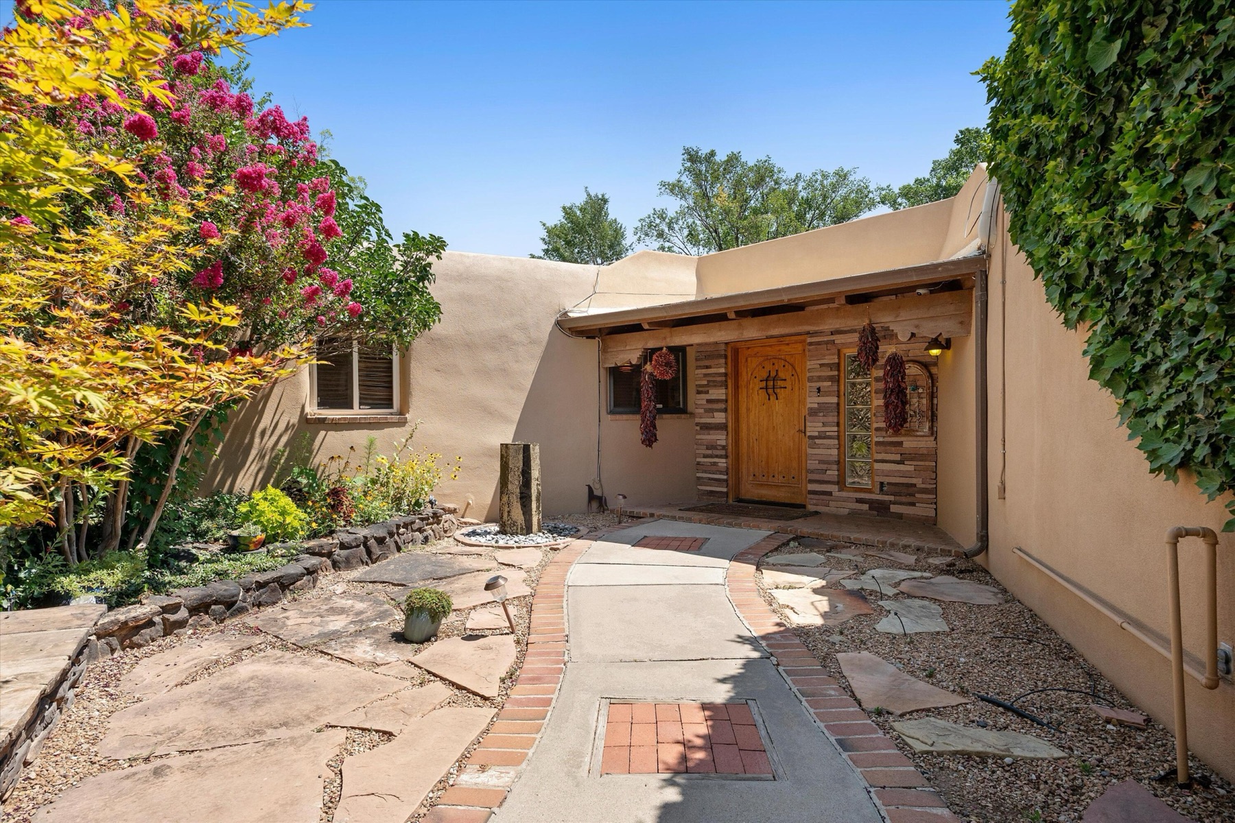 Adobe Pueblo-style entrance and shaded courtyard approach at 4068 Dietz Farm Circle NW in Los Ranchos, New Mexico.