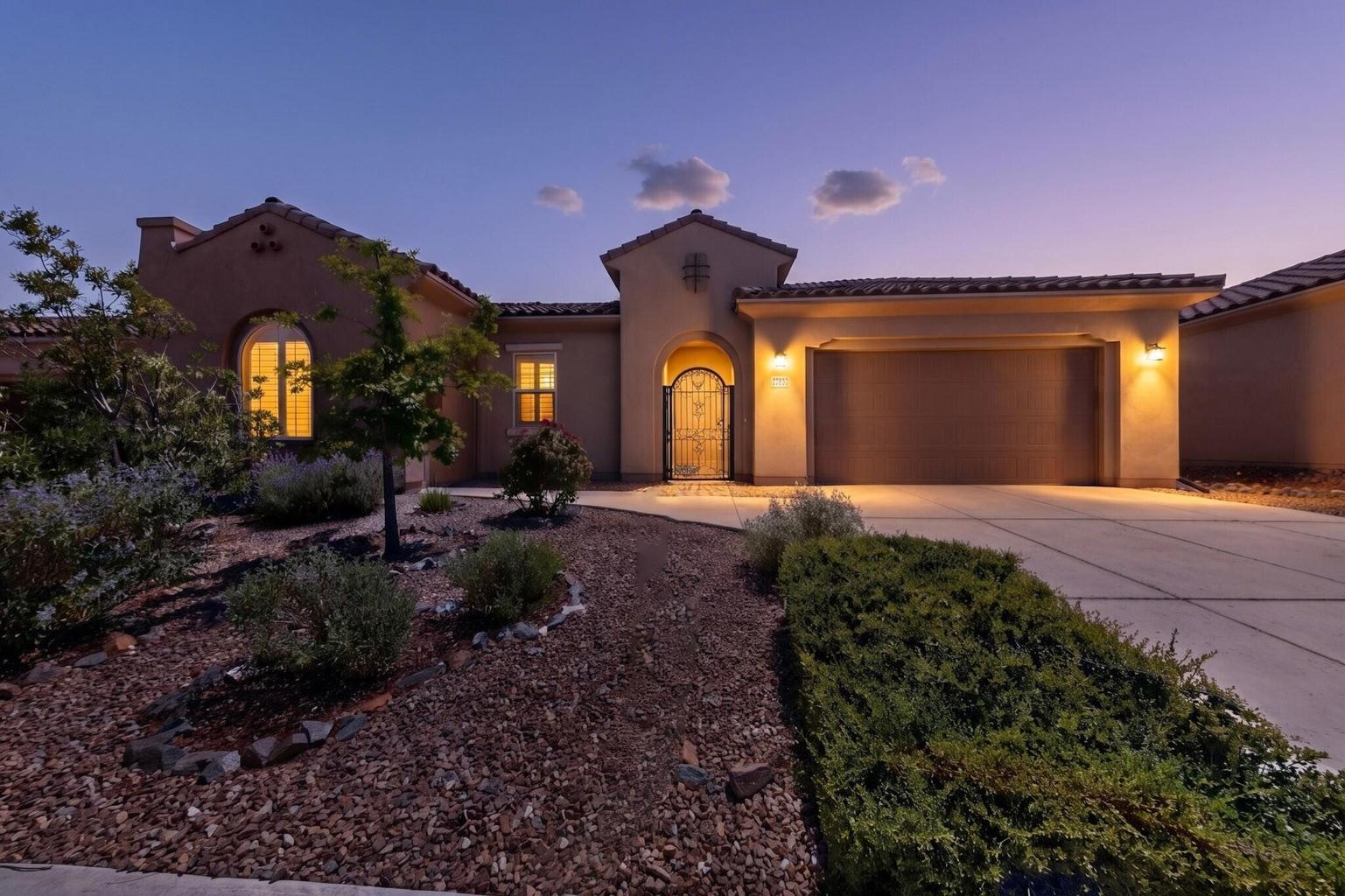 Front exterior at twilight at 4707 Lluvia Encantada in Santa Fe, showing the single-level home and driveway approach.