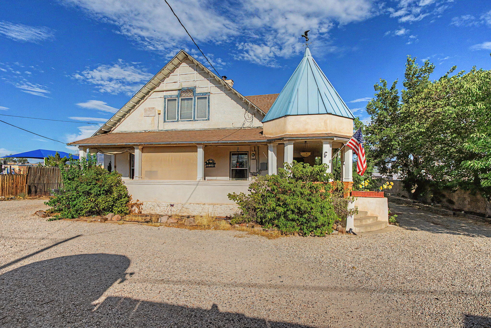 Historic Victorian-style home at 9742 4th Street NW with a wraparound porch and blue-roofed corner turret