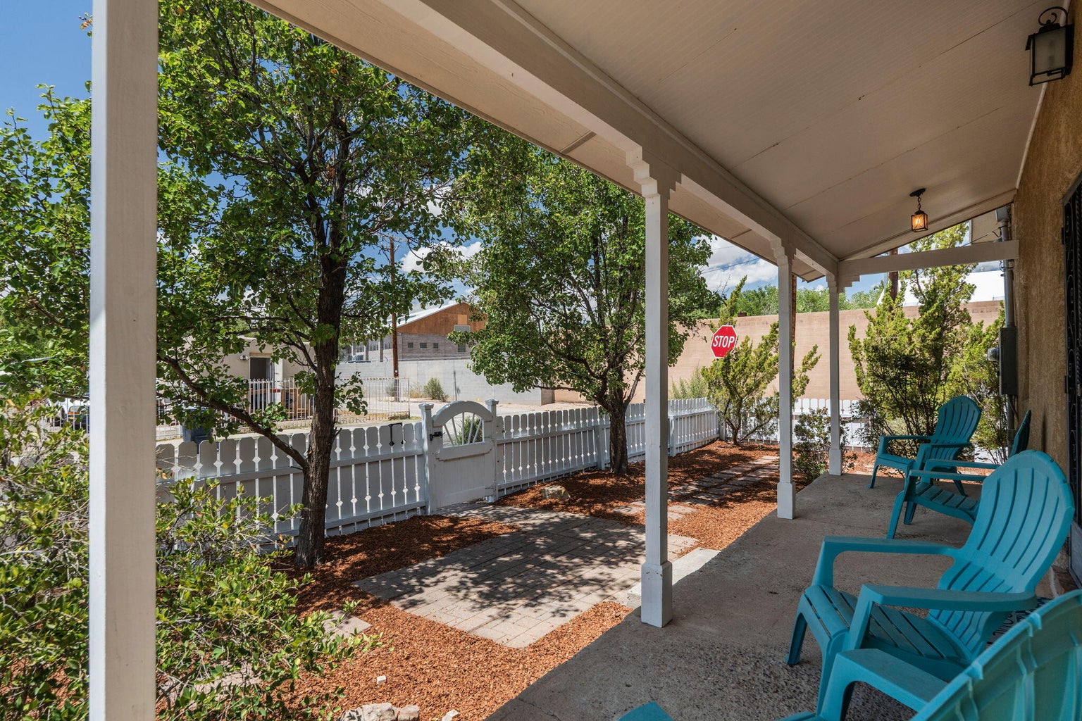 Covered front porch at 1023 11th Street SW in Albuquerque, showing wood posts, ceiling boards, and shaded seating space