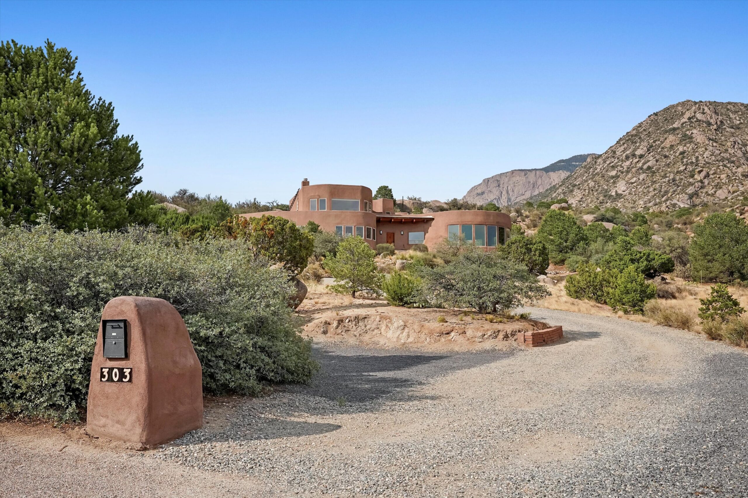 Adobe exterior of 303 Spring Creek Place NE against the Sandia foothills