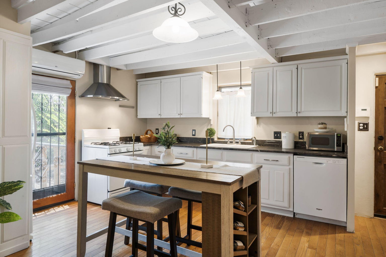 Eat-in kitchen at 1023 11th Street SW with light cabinetry, stone counters, gas range, center island, and a window over the sink