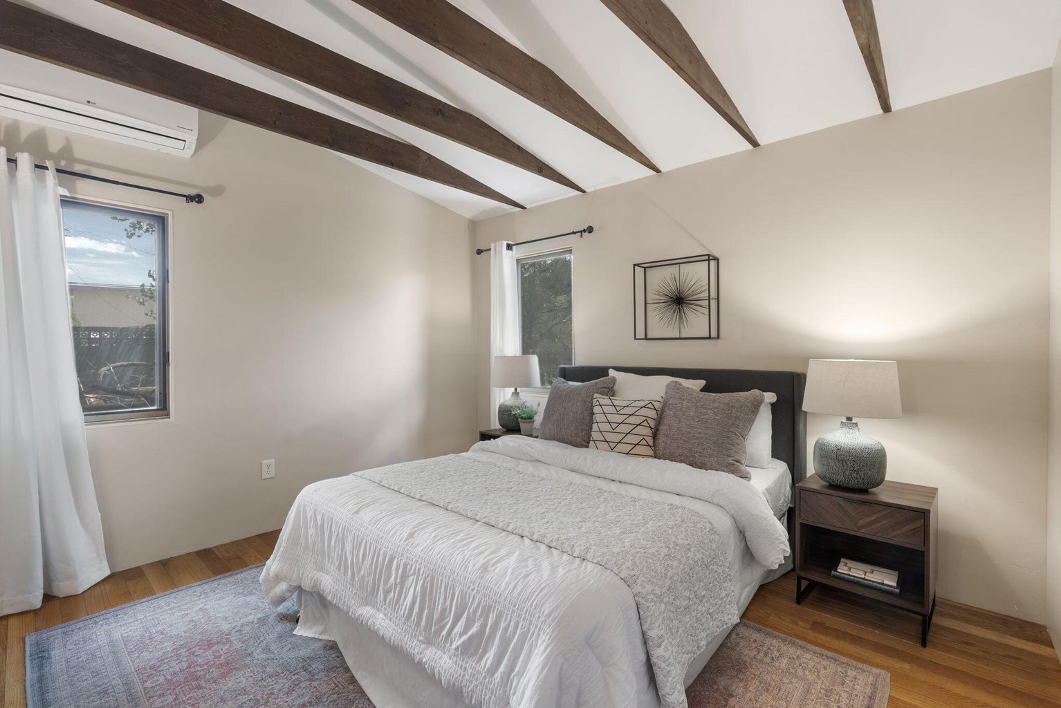 Primary bedroom at 1023 11th Street SW with wood flooring, light walls, and a ductless mini-split unit