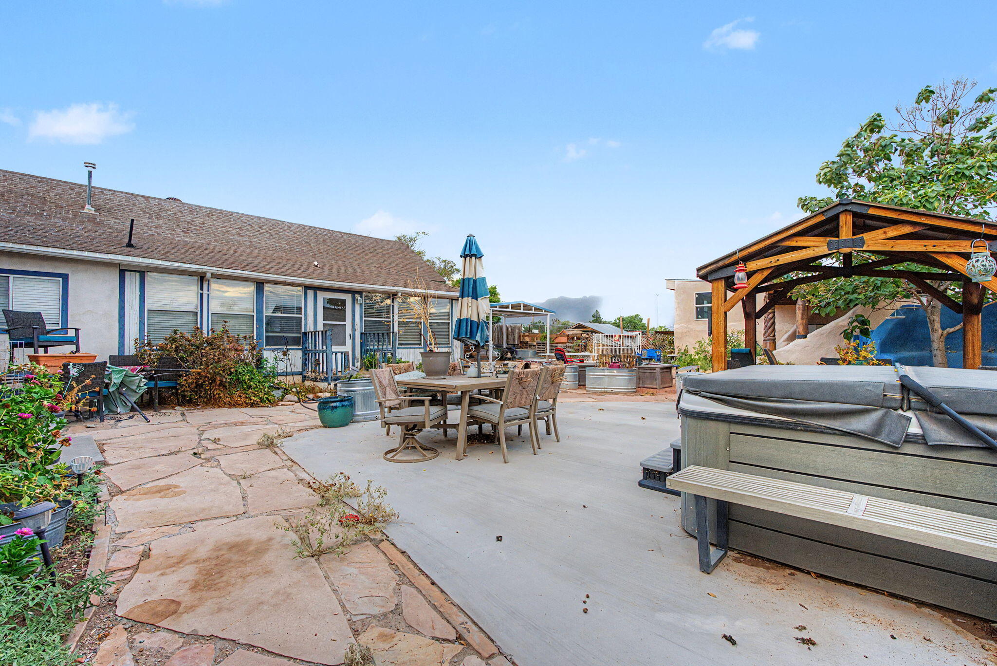 Flagstone courtyard with a gazebo, hot tub, and outdoor seating
