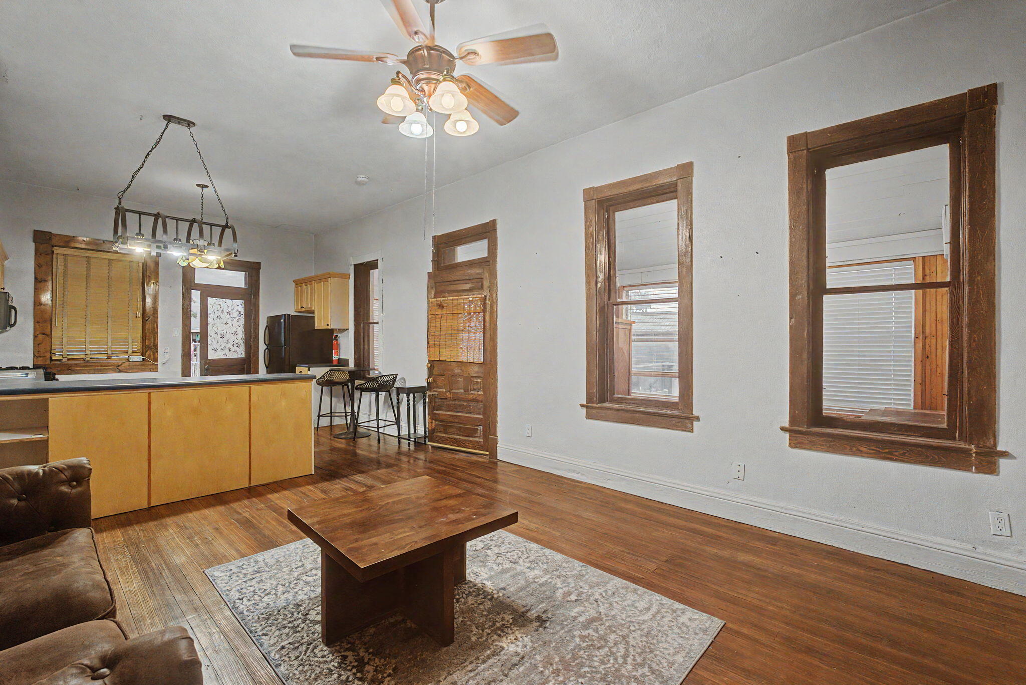 Detached casita living space with wood floors, wood-trimmed windows, and a compact kitchen