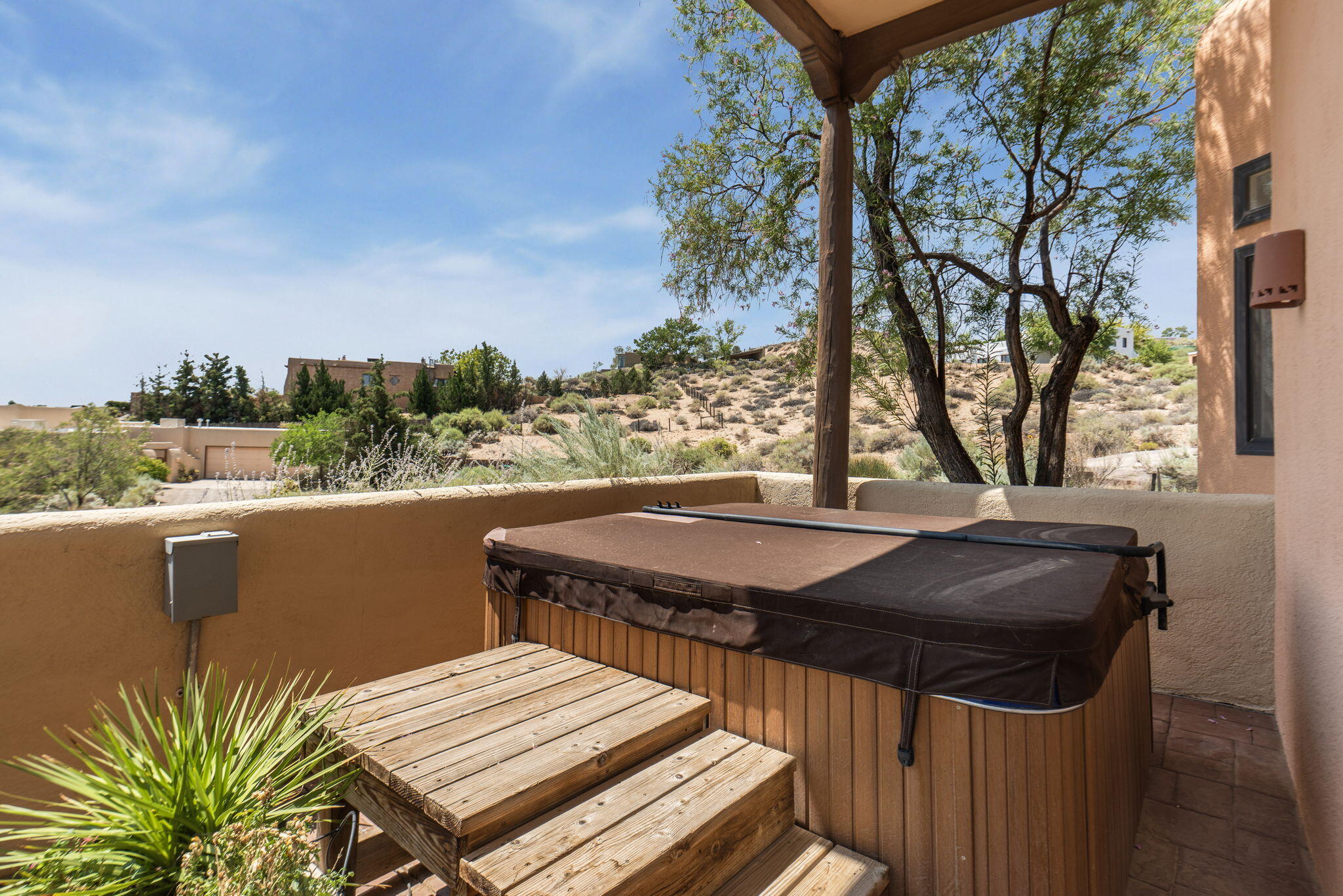 Hot tub and patio at 40 Sereno Road with high-desert landscaping and valley views beyond