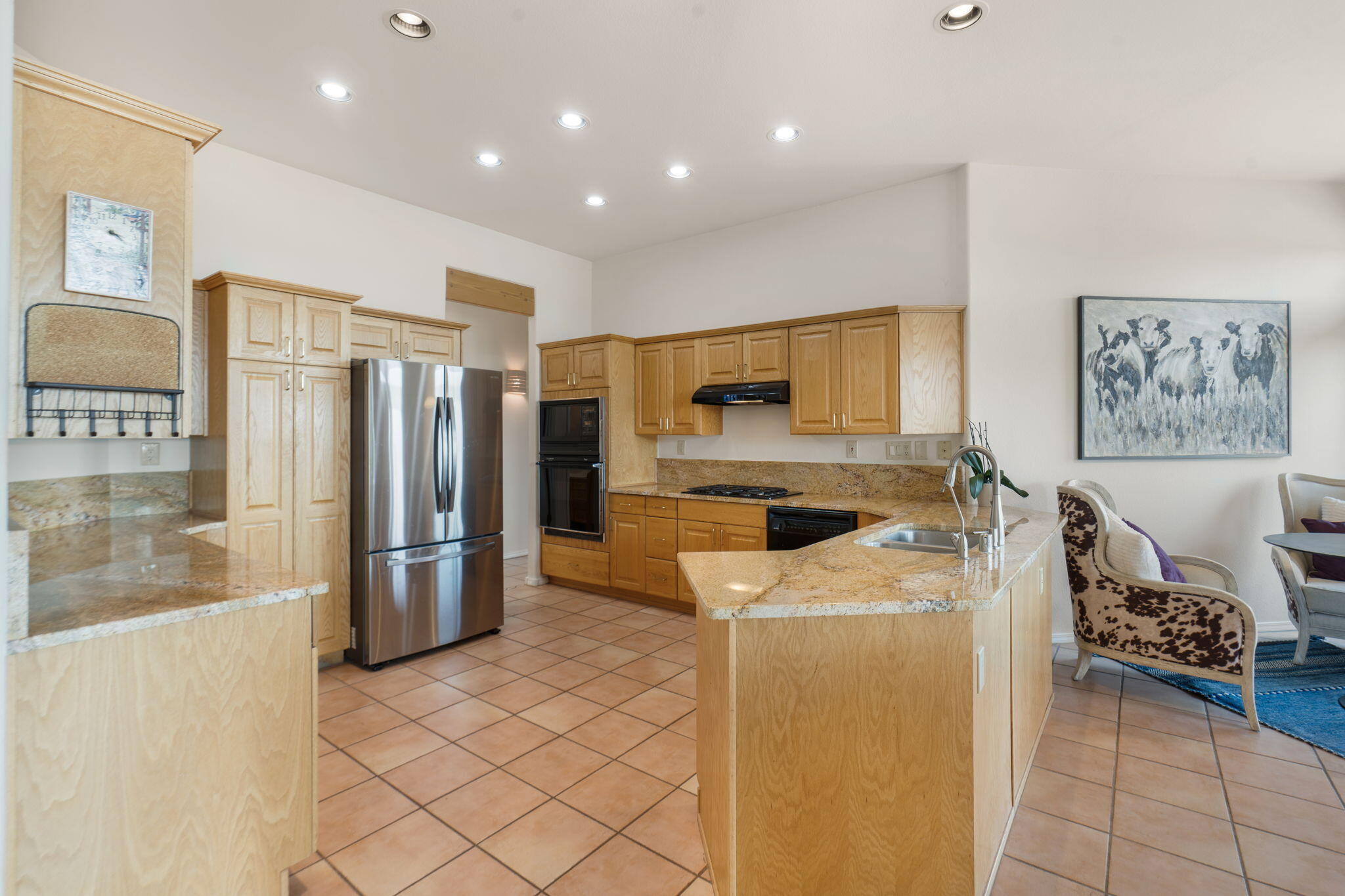 Updated kitchen at 40 Sereno Road with wood cabinetry, granite counters, an island, and an open connection to the living area