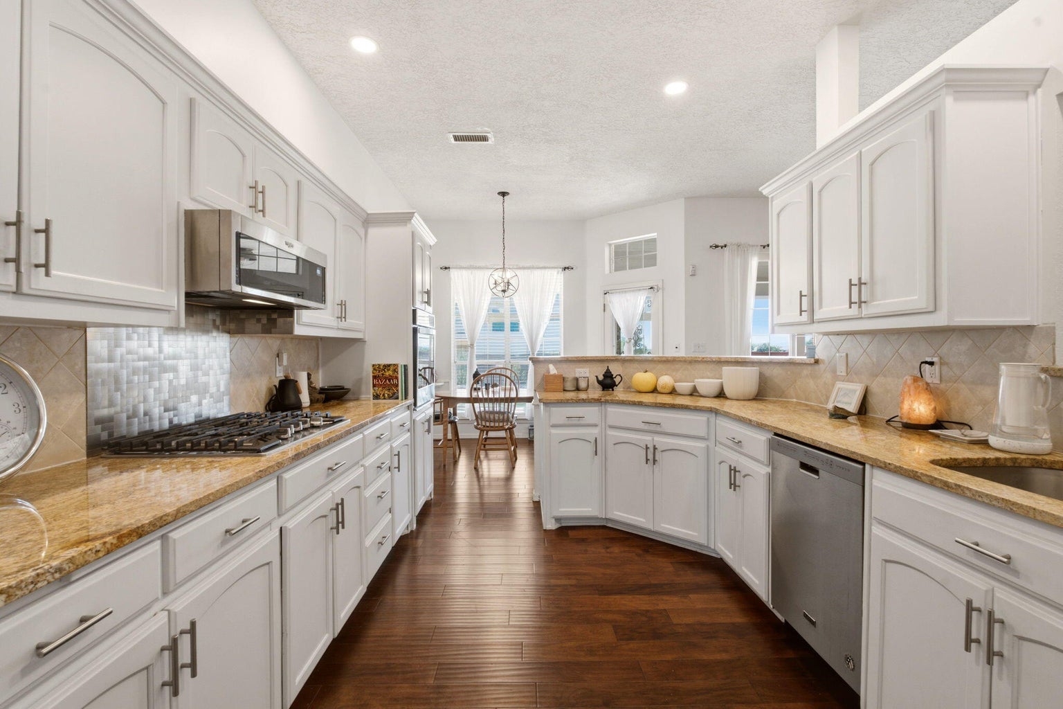Kitchen at 1684 Savannah Court NE with white cabinetry, stone-look counters, a gas cooktop, stainless appliances, and an adjacent dining area.