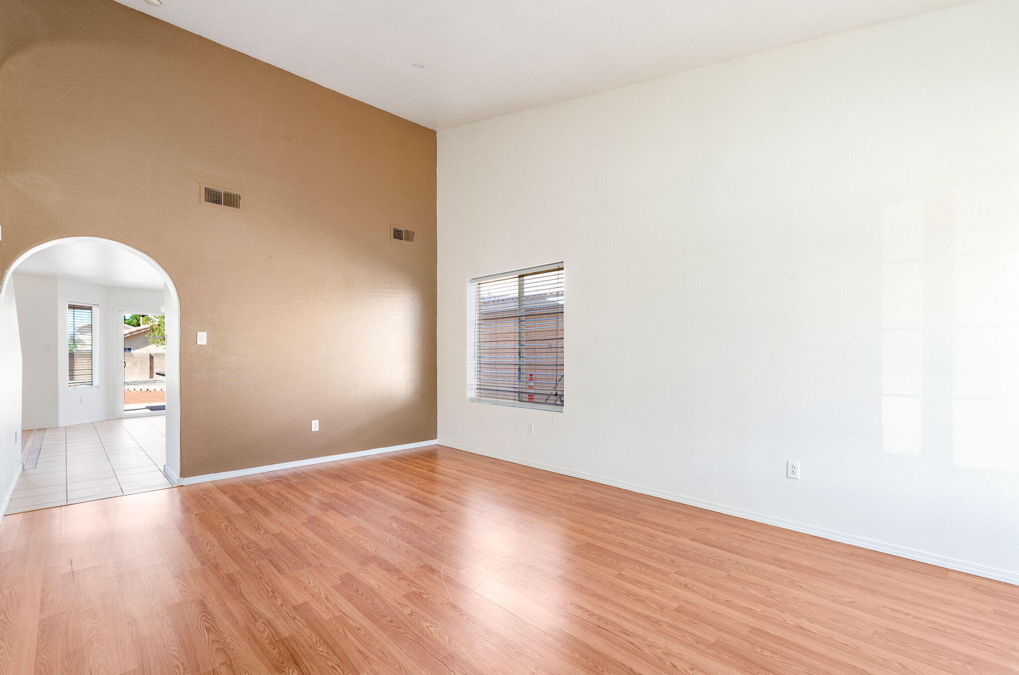 Front living room with high ceiling and an arched opening toward the kitchen.
