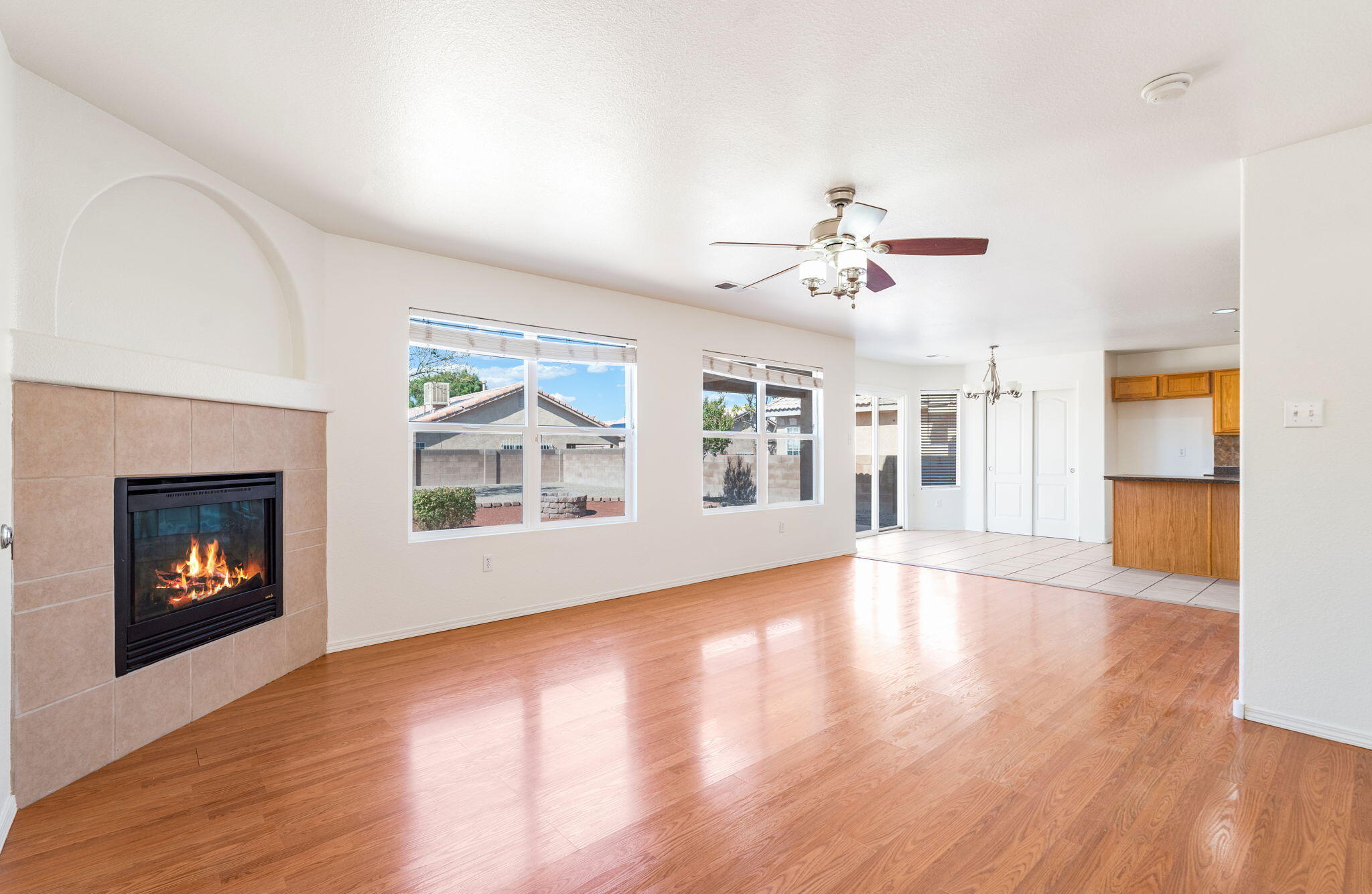 Family room with gas-log fireplace, backyard-facing windows, and connection to the kitchen.