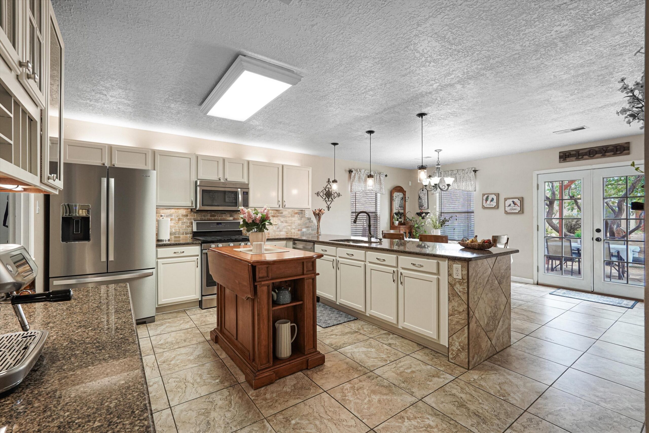 Open kitchen with white cabinets and granite counters at 10536 Vista Bella Place NW