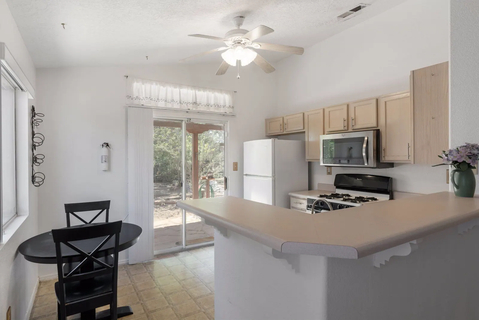 Breakfast bar and kitchen at 6004 Cyonus Avenue NW facing a sliding glass door to the covered patio