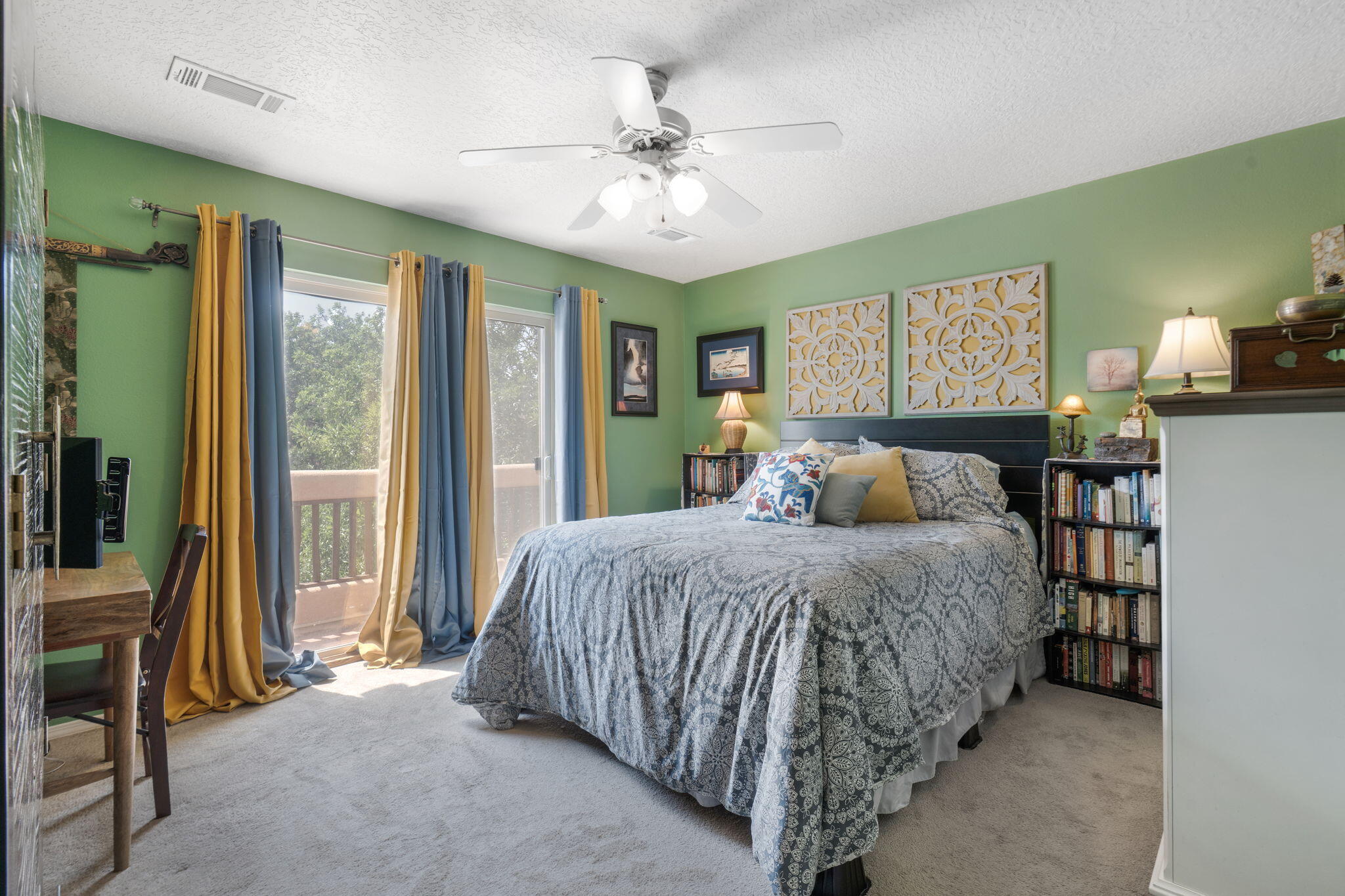 Primary bedroom with green walls and doors to the deck at 3601 Calle Oveja Court NW