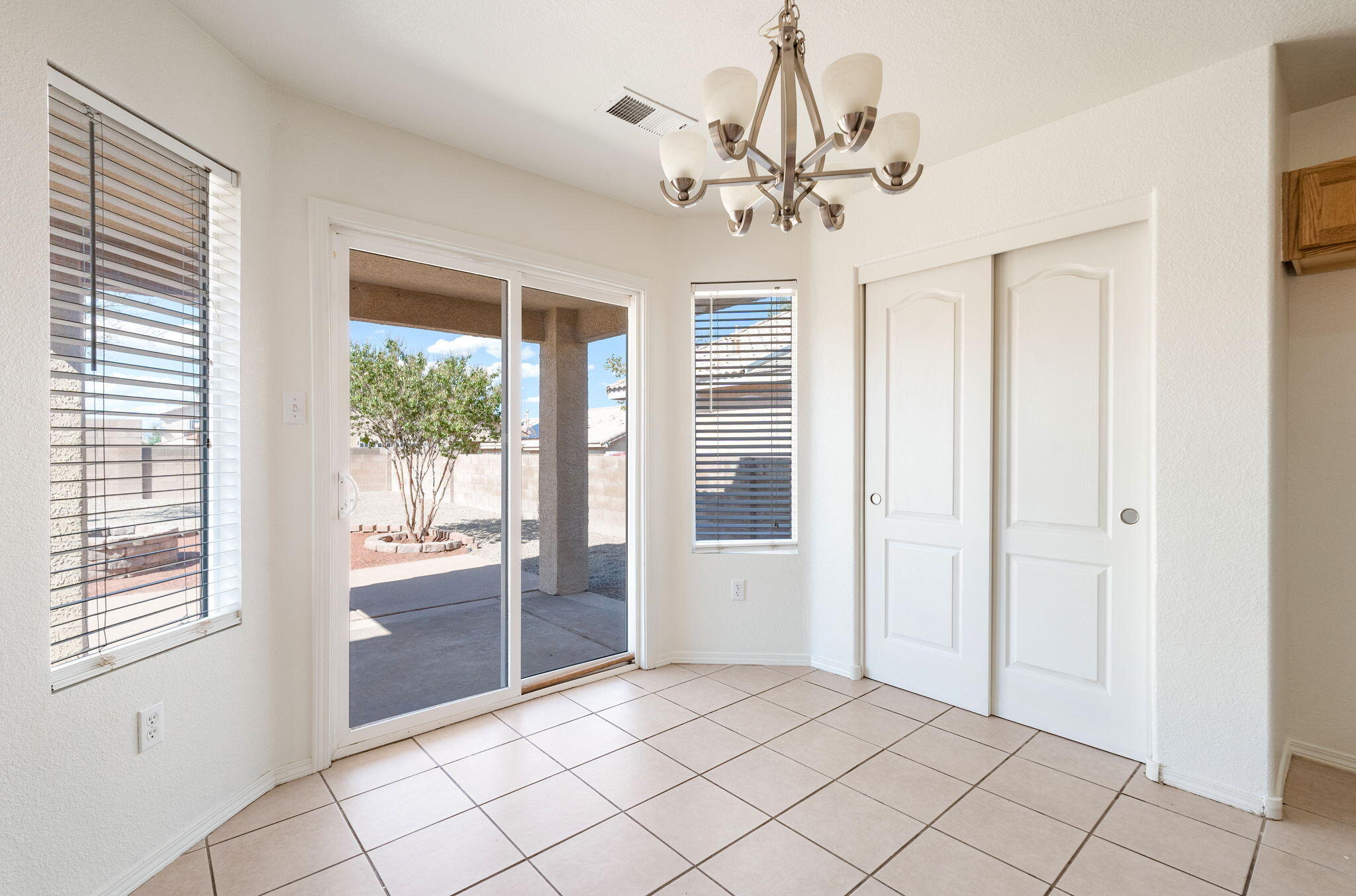 Breakfast nook with windows and a sliding door opening onto the covered patio.