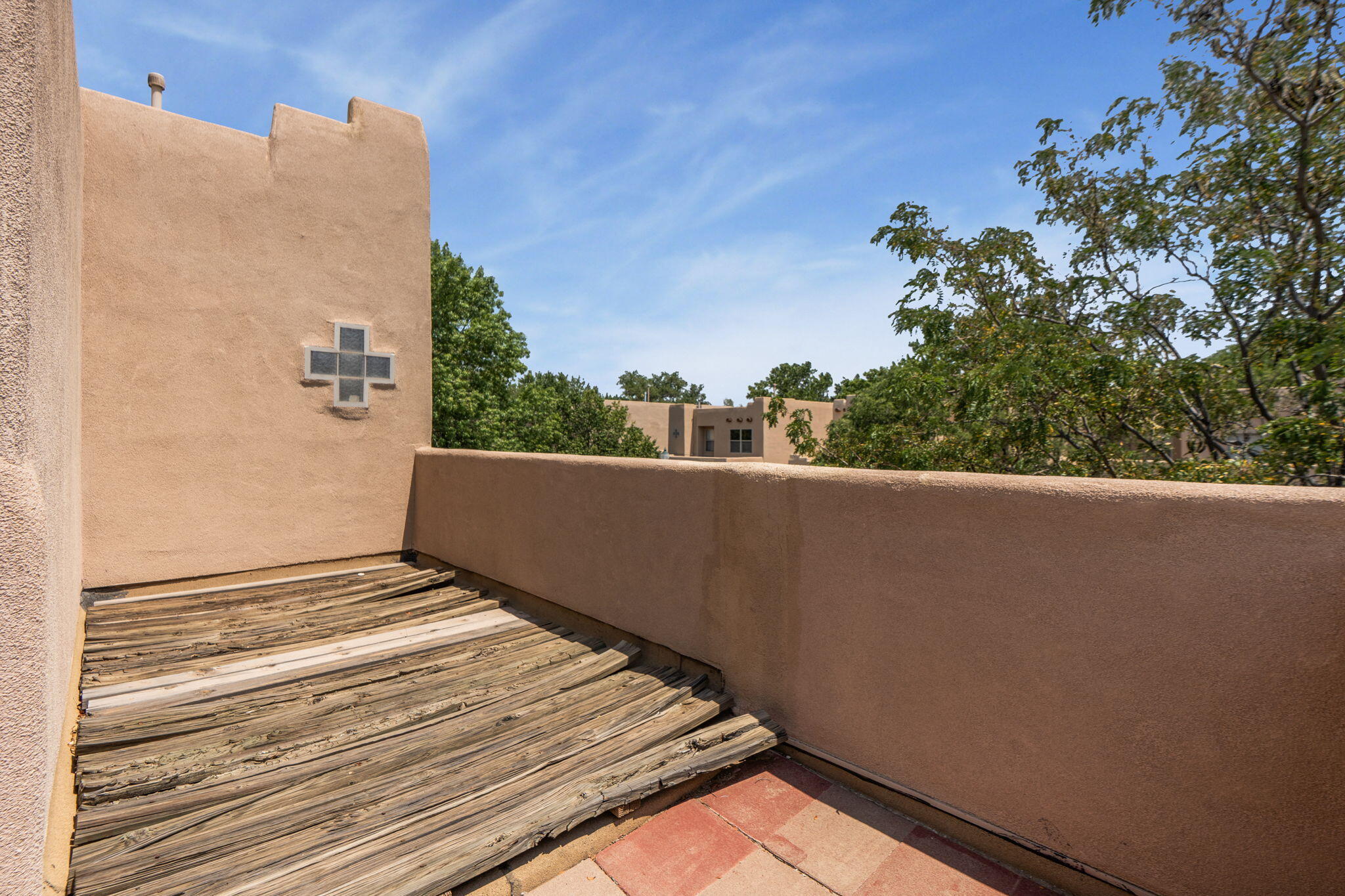 Private upper-level deck with stucco walls and treetop views at 3601 Calle Oveja Court NW