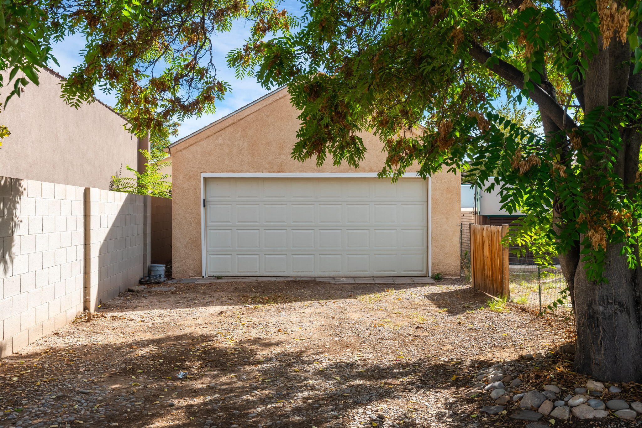 Separate two-car garage at 406 Atrisco Drive SW shaded by a mature tree