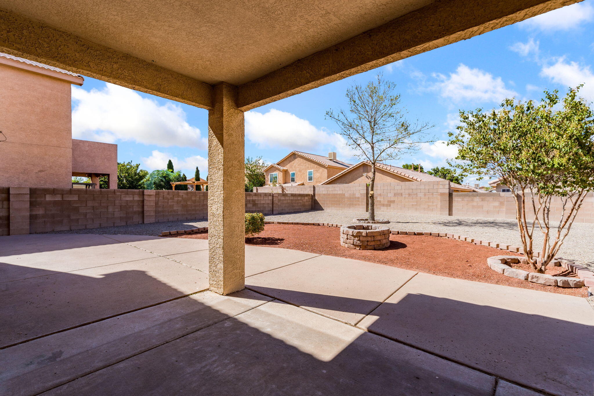 Covered patio overlooking the enclosed backyard and gravel landscaping.