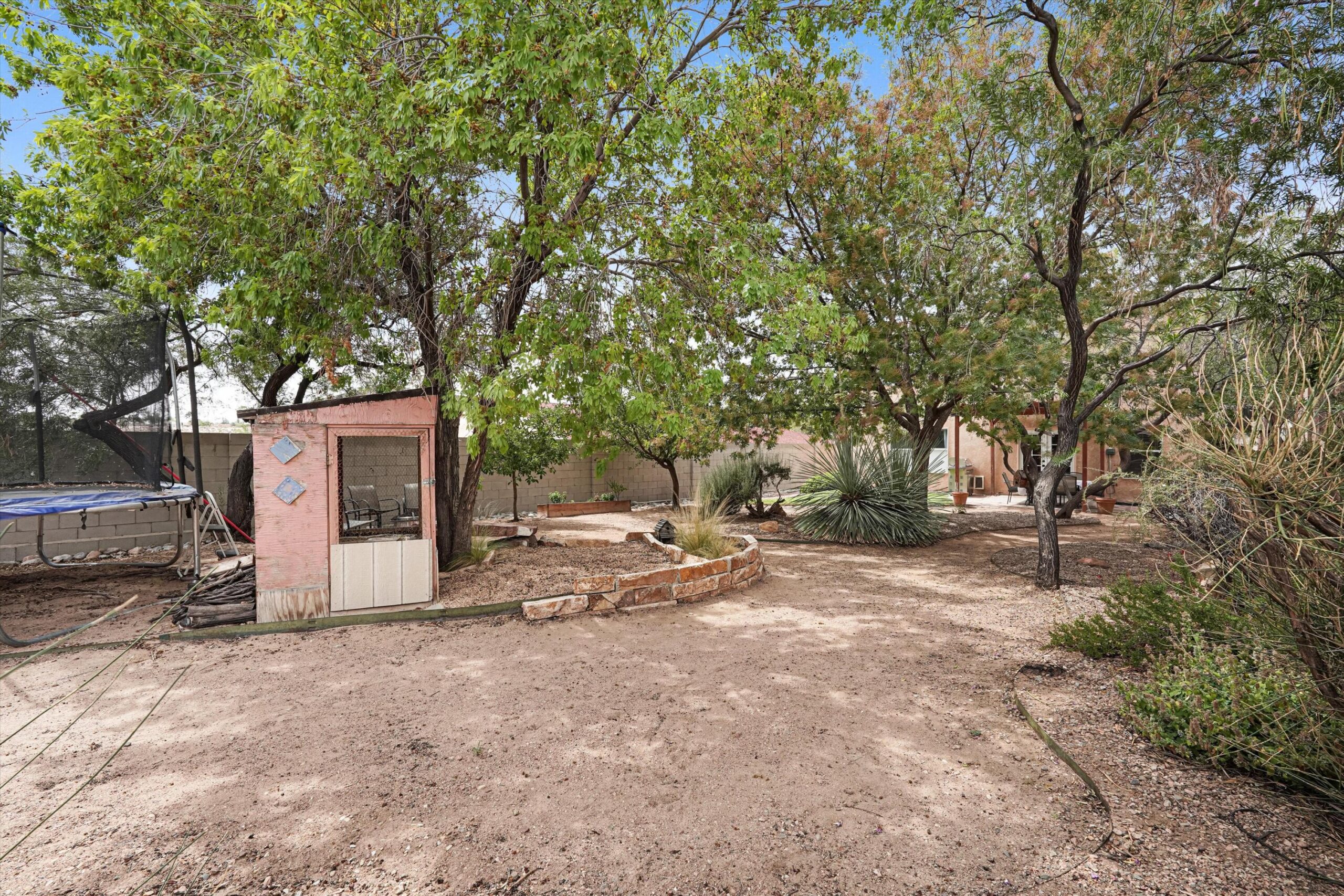Separate backyard garden and poultry coop area among mature trees