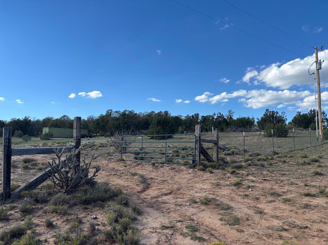 Fenced entrance gate and open terrain on the Bosque View parcel