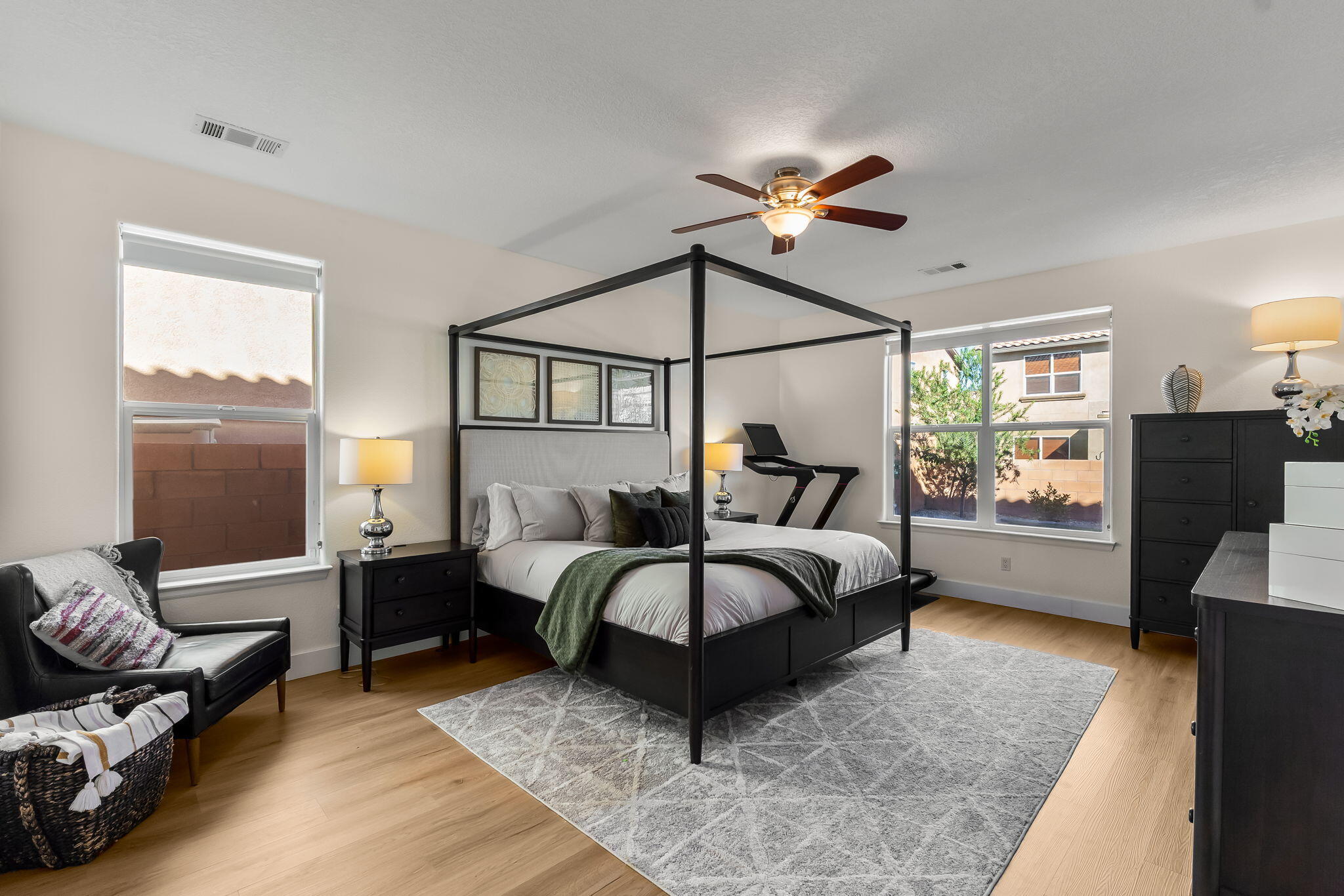 Main-level primary suite with windows and a canopy bed at 22 Monte Vista Drive NE