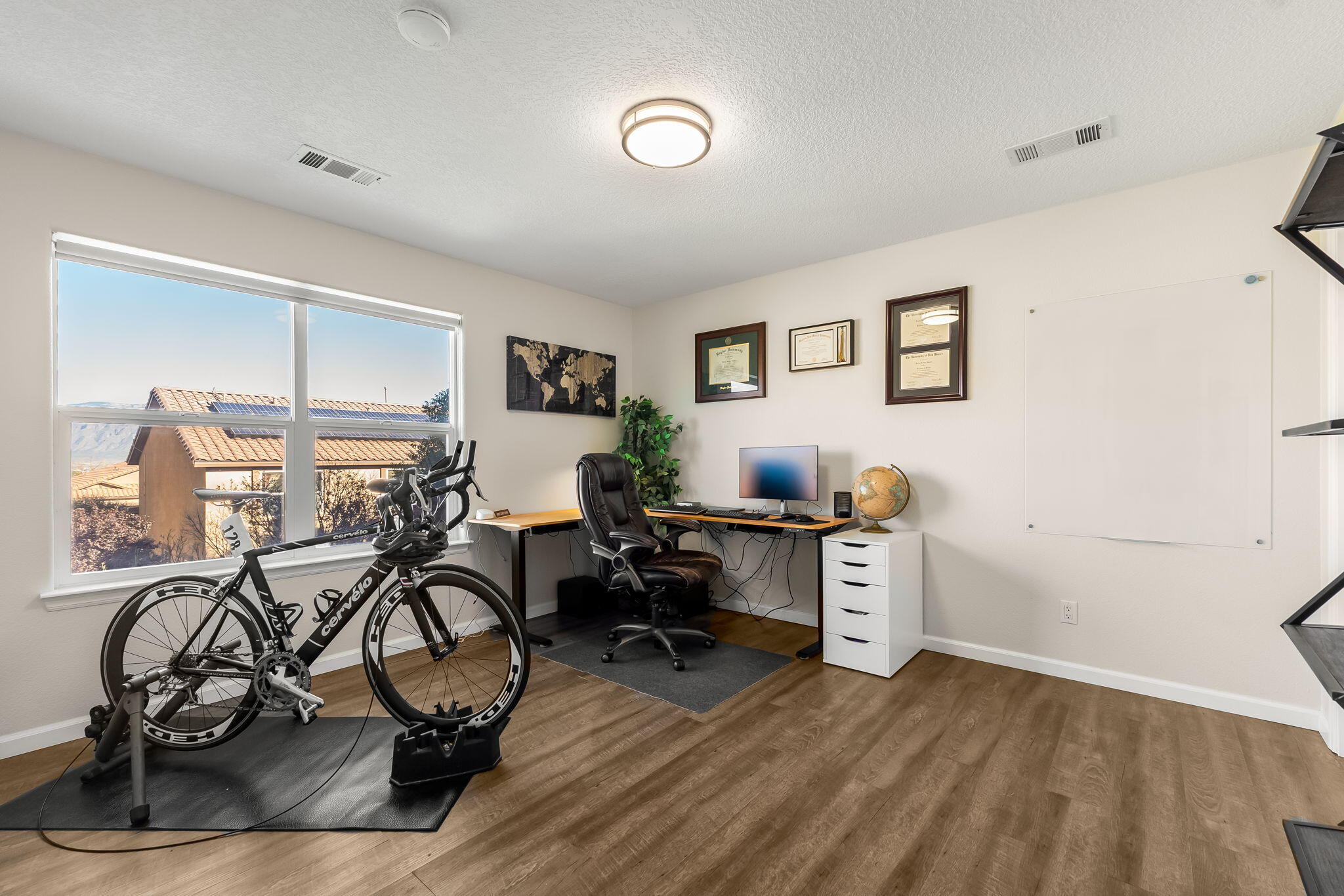 Upstairs room arranged with a desk and indoor bicycle setup at 22 Monte Vista Drive NE