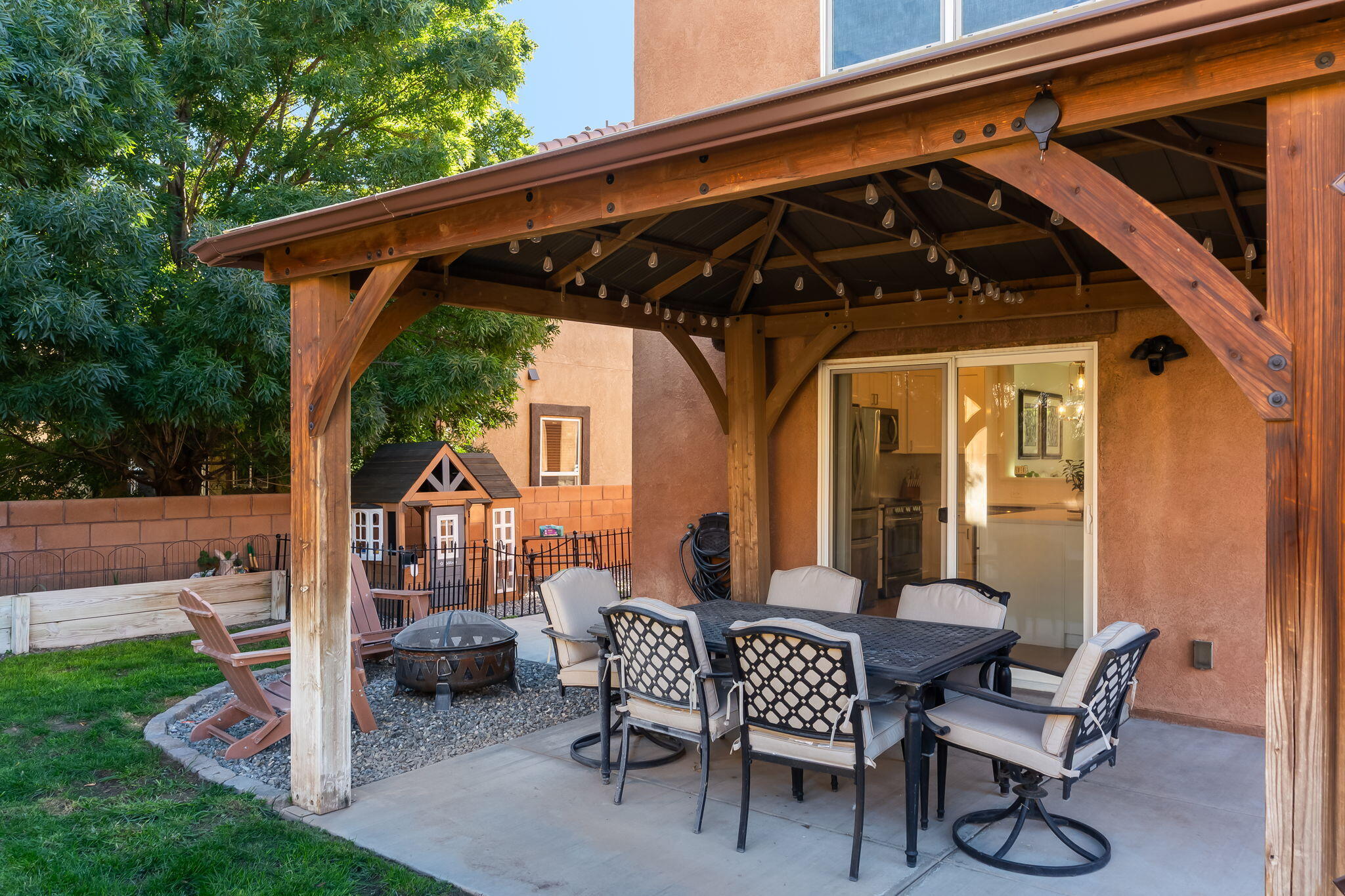 Timber-covered patio with outdoor dining furniture beside the kitchen sliding door at 22 Monte Vista Drive NE