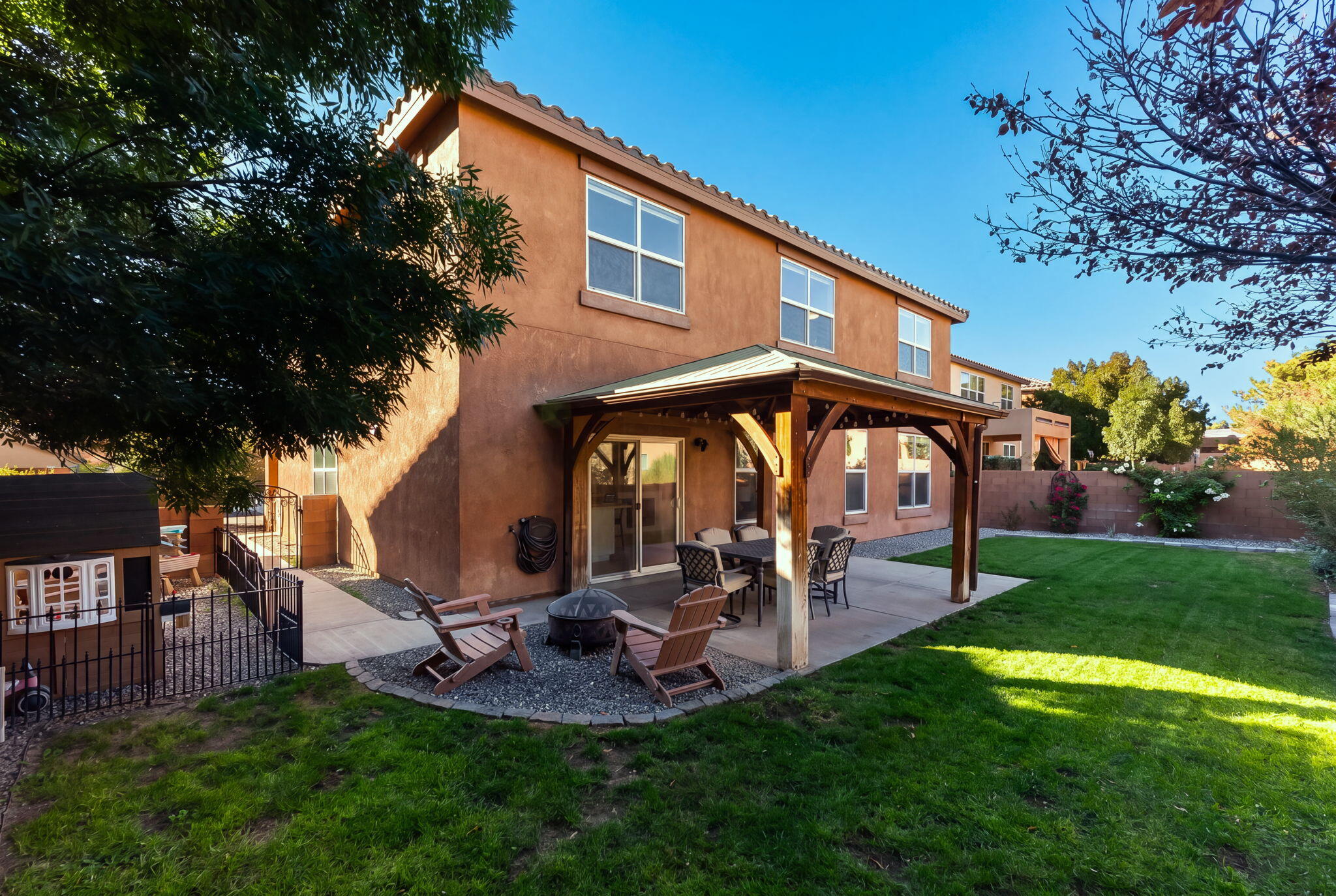 Landscaped east-facing backyard and covered patio at 22 Monte Vista Drive NE in Loma Colorado